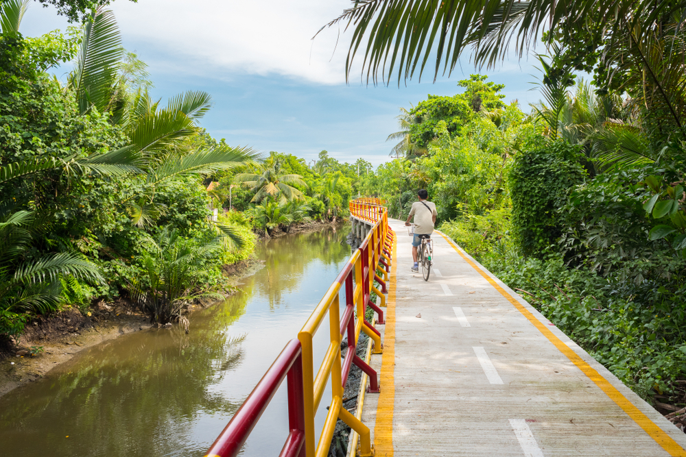 A cyclist riding through Bang Krachao. This is one of the best outdoor activities in Bangkok.

